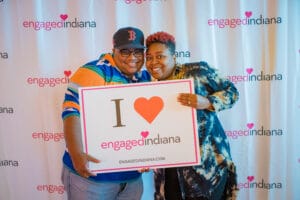 2 People Standing With The banner of " I Love Engaged Indiana "