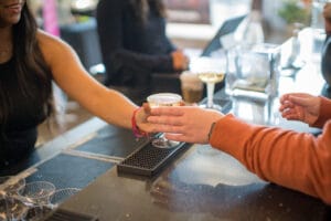 A man taking a glass of liqurium