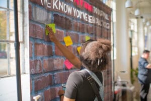 A Women is pasting a paper clip on the wall