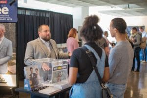 A Man telling something to 2 people in the event