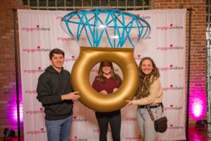 3 People are taking photo with ring shape ballon