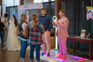 A man is talking to a couple of womens in the fashion show