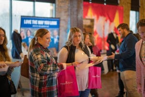 A man talking to couple of womens in the event